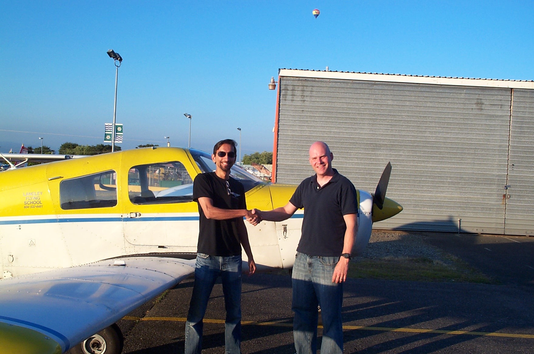 Carl Tingstad receives contrats from his Flight Instructor, Mayank Mittal.  Langley Flying School.